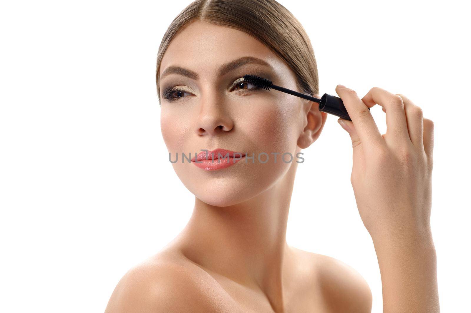 Gorgeous young female holding mascara brush isolated on white by SerhiiBobyk