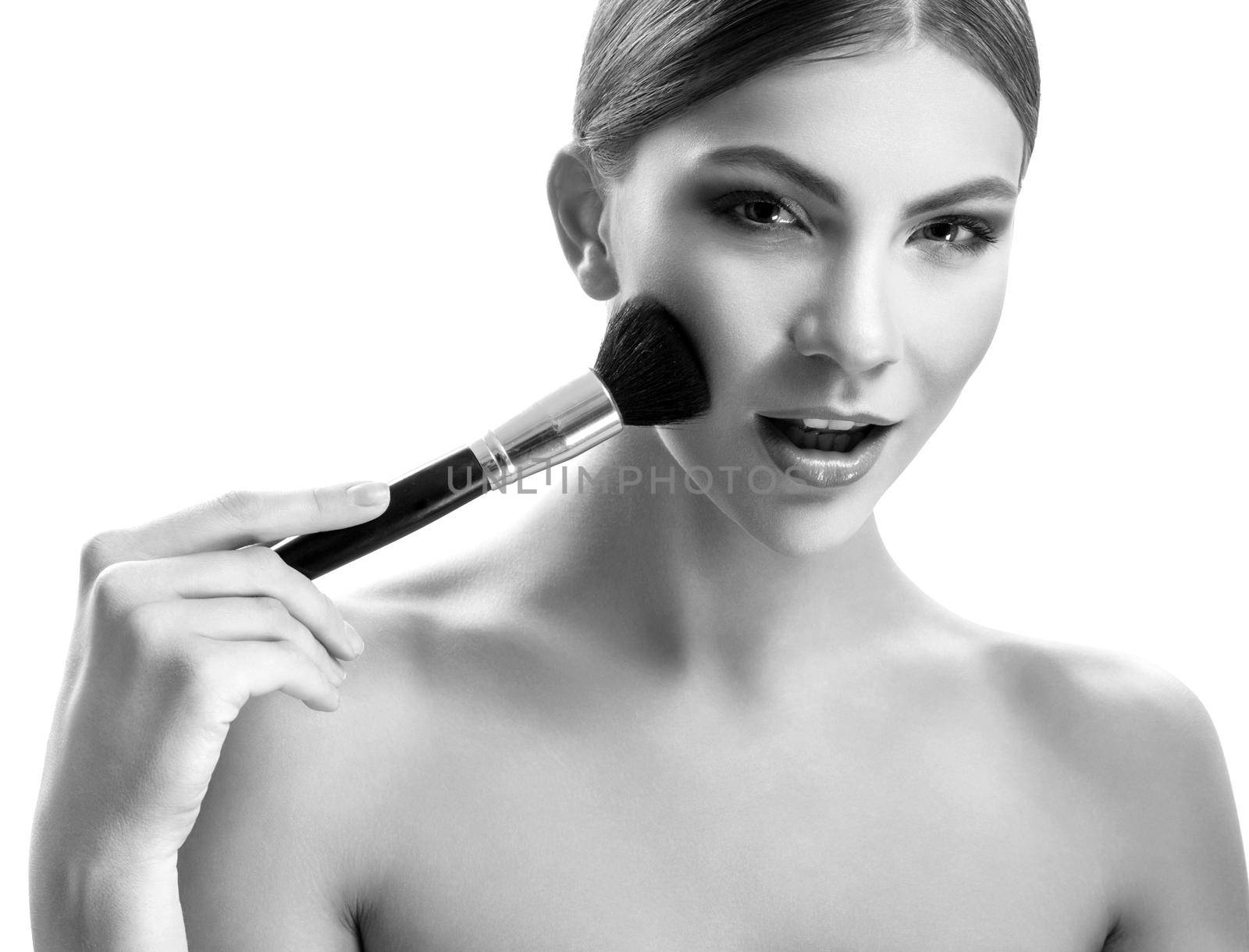 Gorgeous young woman holding makeup brushes isolated on white by SerhiiBobyk