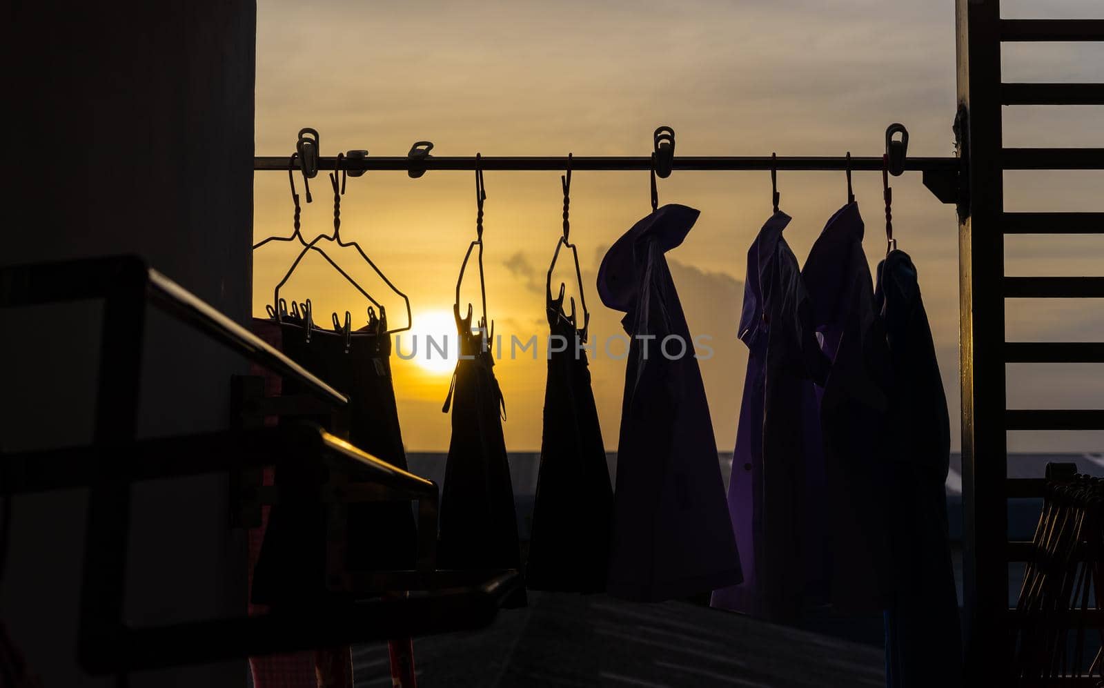 clothes hanging on the clothesline with sunset by domonite