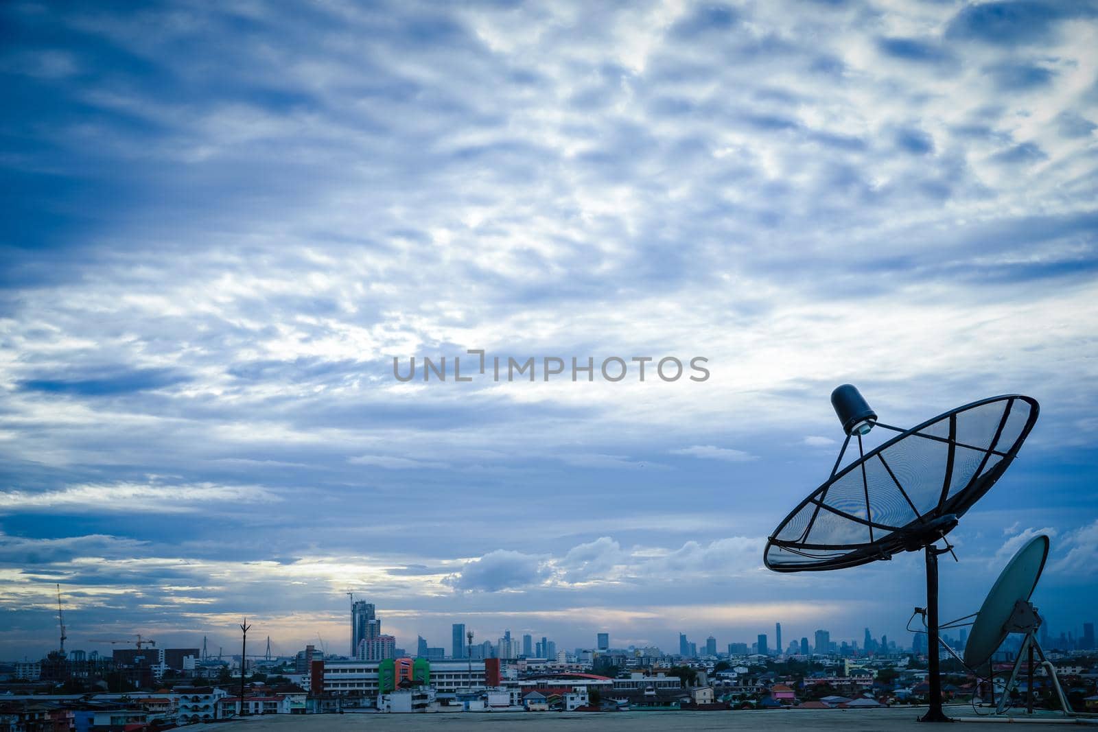 Satellite dish antenna on top of the building in urban area at morning