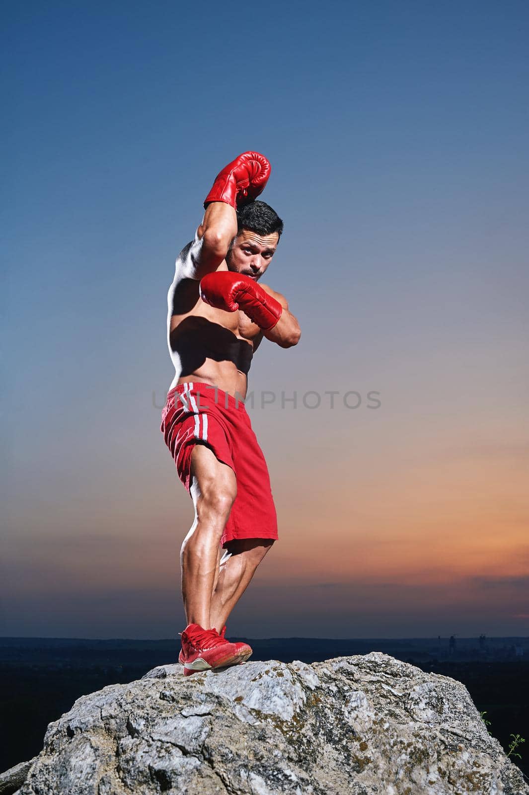 Muscular male boxer training outdoors by SerhiiBobyk