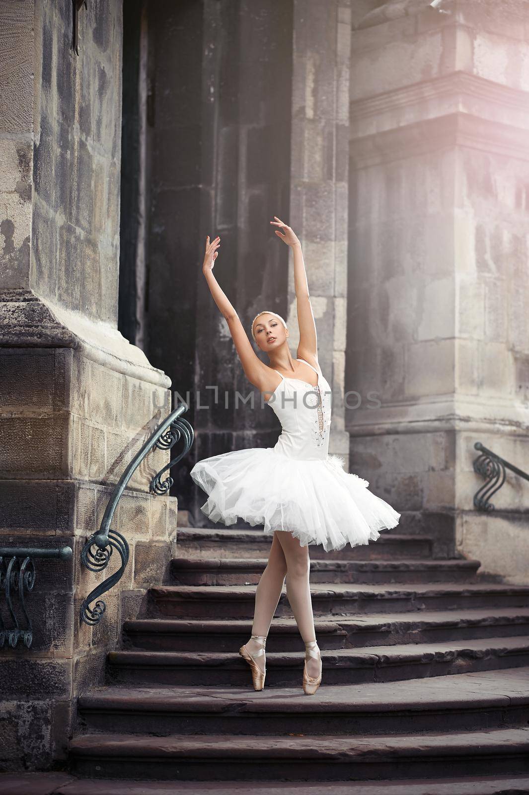 She can teach you grace. Vertical soft focus portrait of a stunning ballet dancer woman performing on the stairway of an old castle