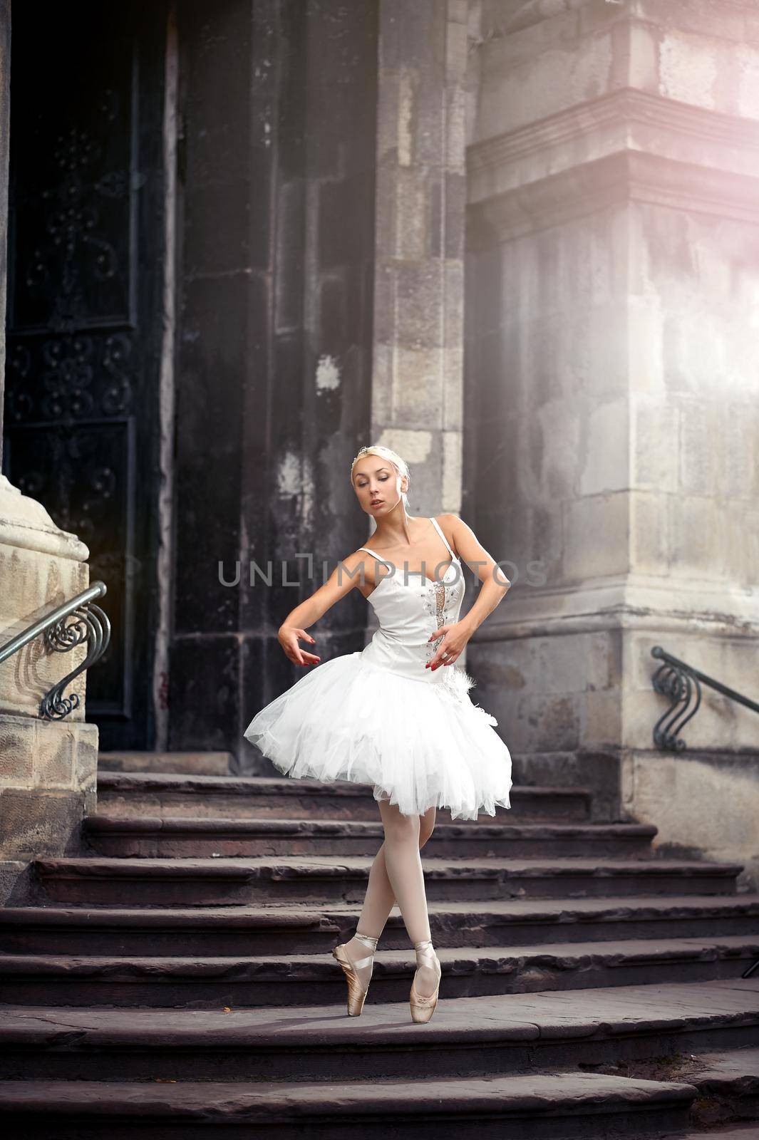 Ballet is her life. Vertical portrait of a gorgeous girl performing ballet outdoors on the stairway of an old castle