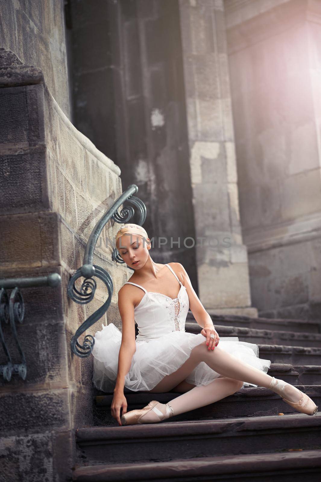 Passion in every curve. Shot of a stunning ballerina resting near on old castle on the stairs