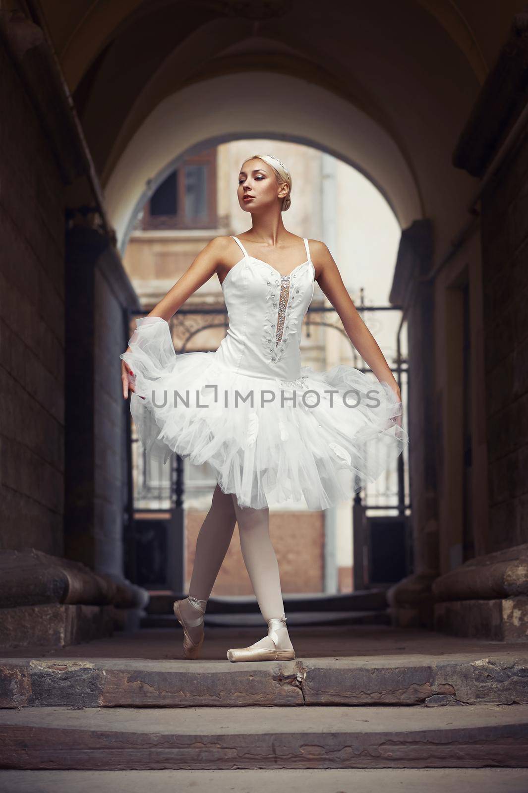 Perfect pirouette. Portrait of a stunning ballerina walking through the archway