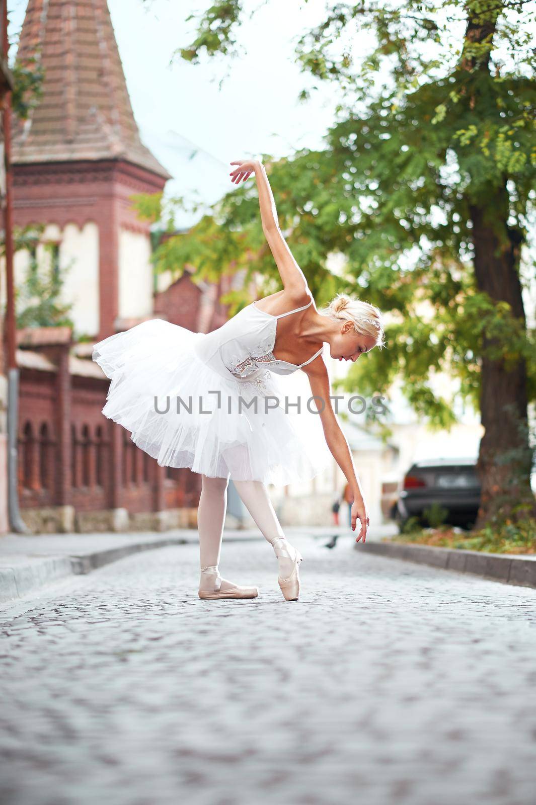 Beautiful graceful ballerina dancing on the streets of an old ci by SerhiiBobyk