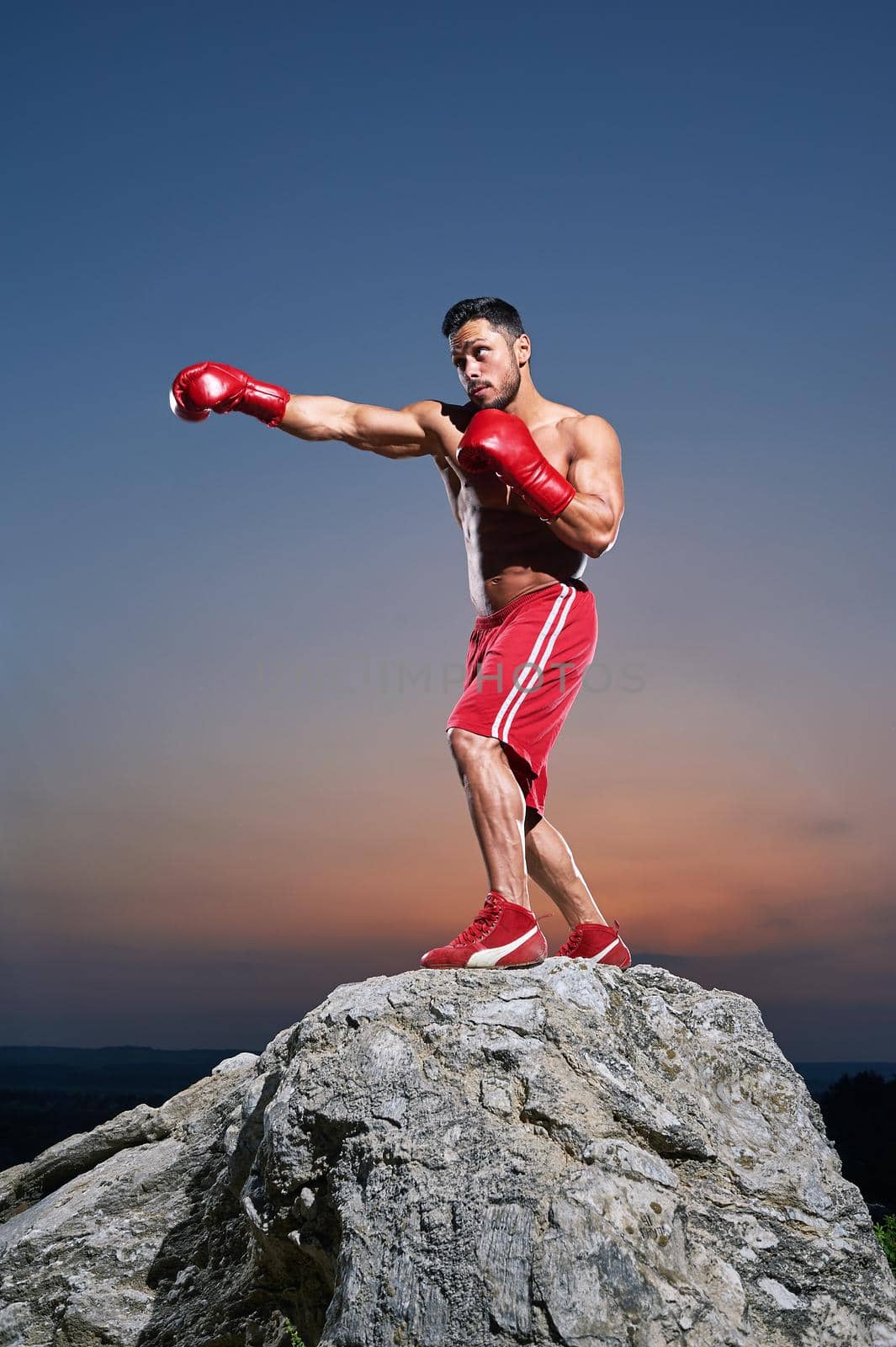 Muscular male boxer training outdoors by SerhiiBobyk