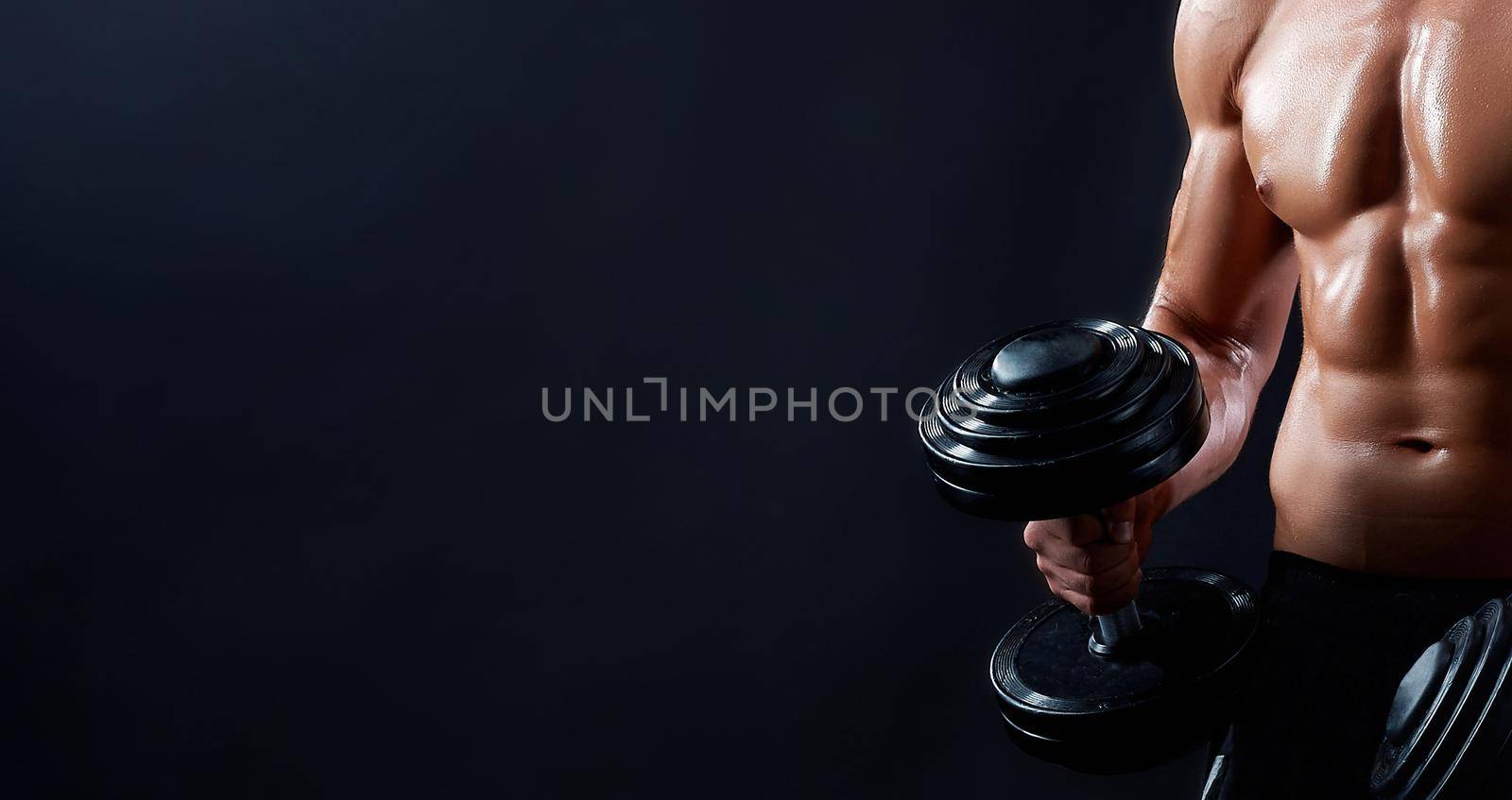 Perfect body. Cropped closeup of a fitness man posing with dumbbells showing off his strong and muscular body