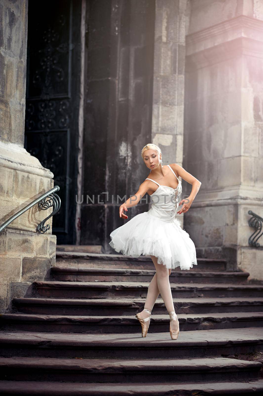 Statuesque ballerina. Young ballerina wearing all white practicing in an old castle