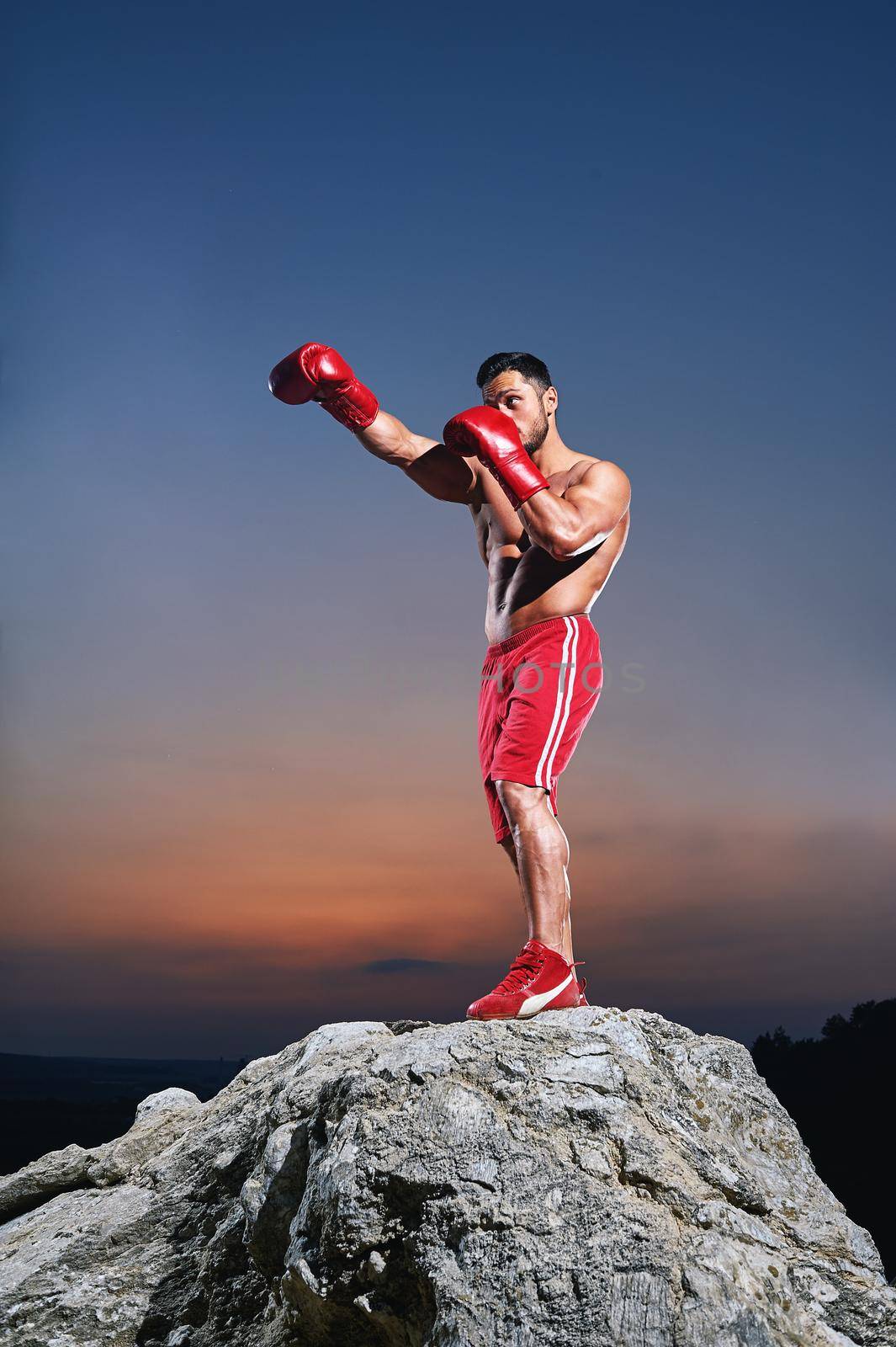 Muscular male boxer training outdoors by SerhiiBobyk