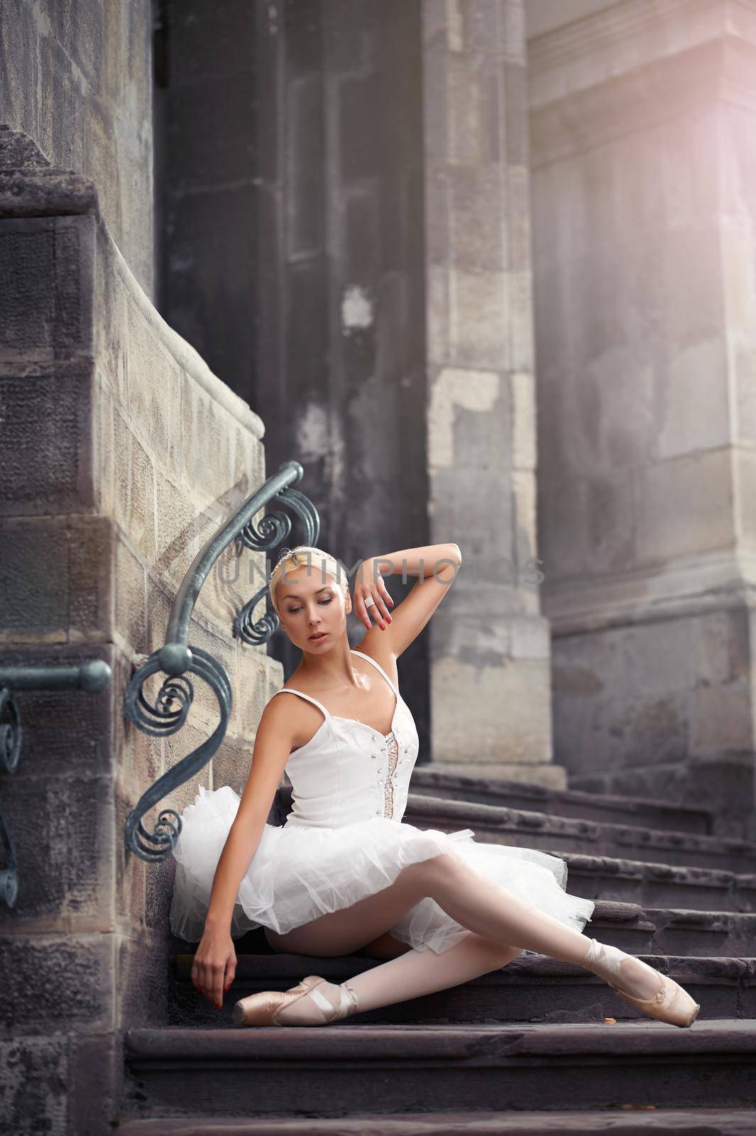 Angelic look. Cropped shot of an elegant ballet lady posing on the stairway of an old building