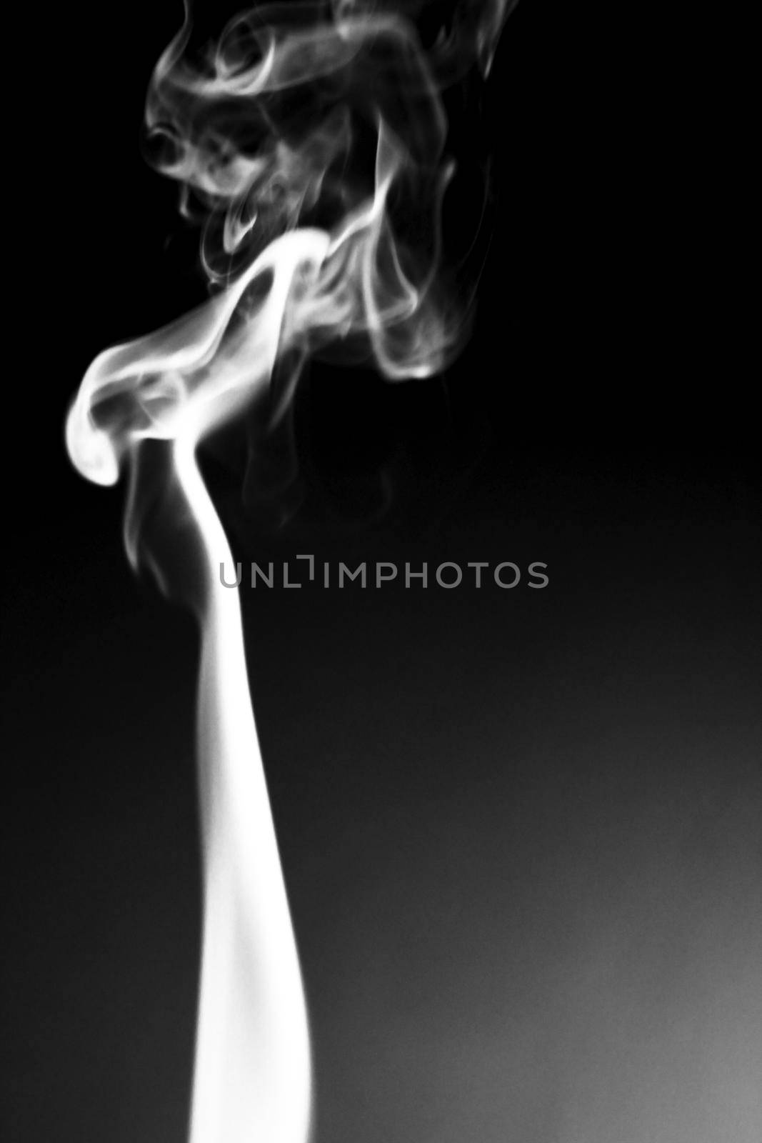 Incense cone shooting beautiful smoke on black background