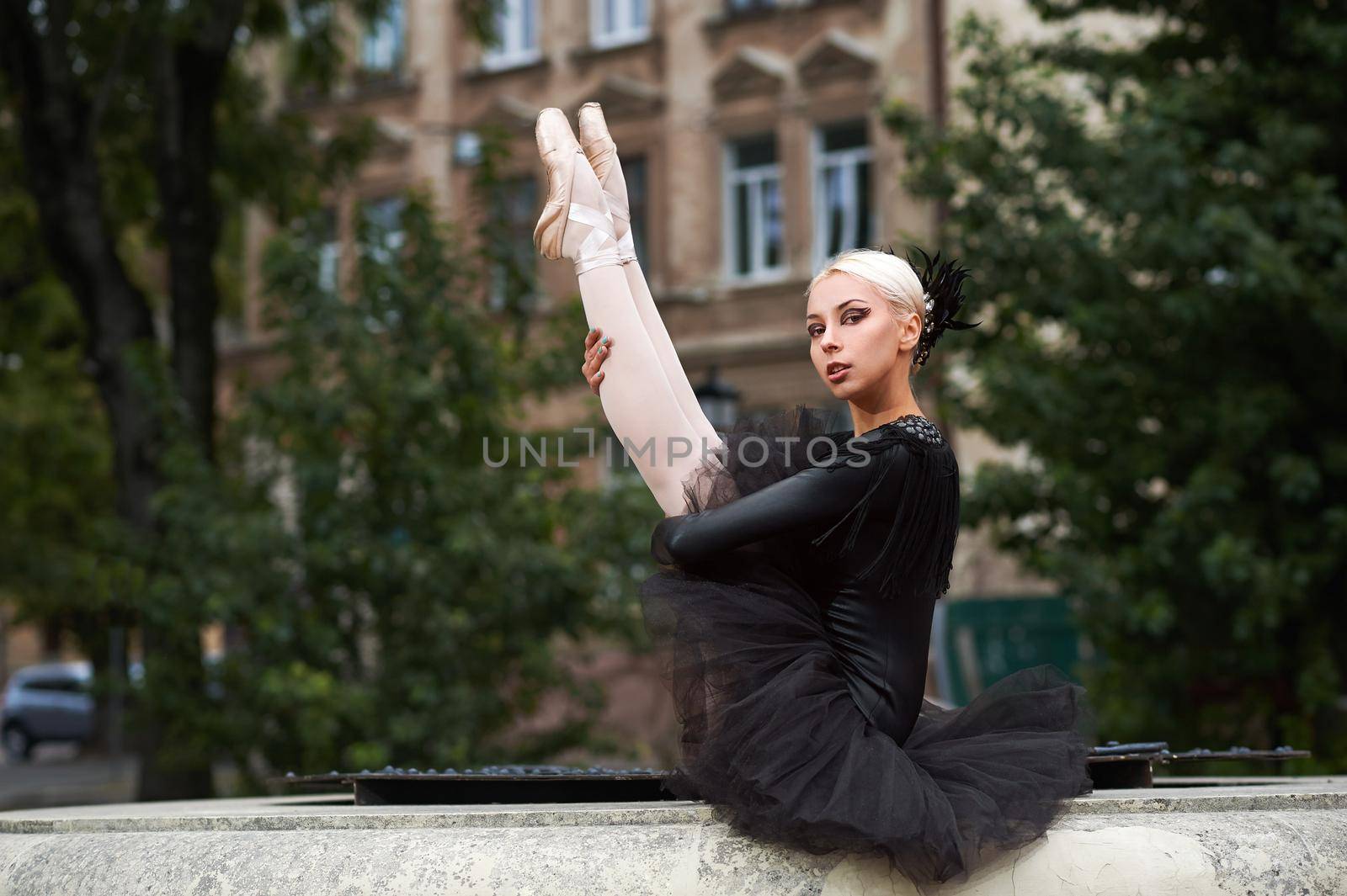 Shot of a gorgeous blonde haired young ballerina wearing black dress sitting outdoors posing gracefully looking to the camera copyspace balance beauty art performance dancer.