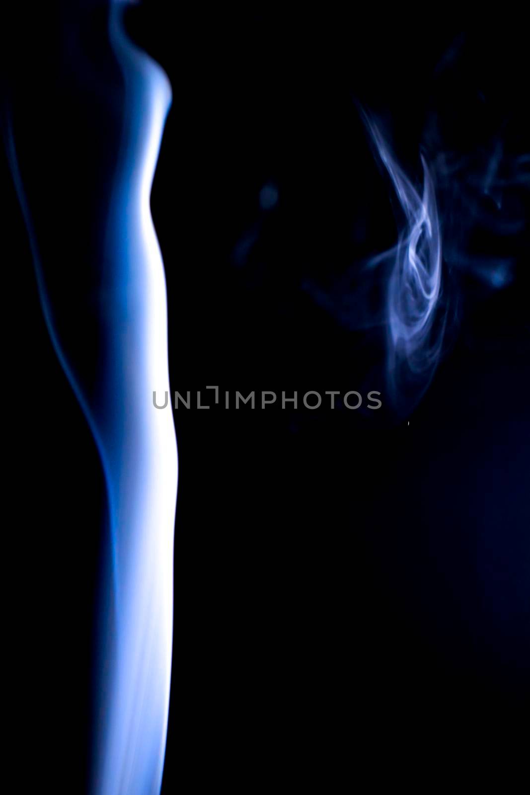 Incense cone shooting beautiful smoke on black background
