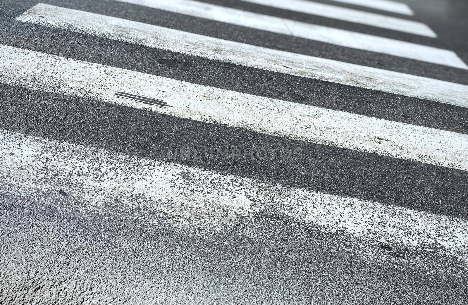 pedestrian crossing of a street with worn and ruined asphalt. Zebra crossing in a European city. Road signs and pedestrian crossing. Road safety