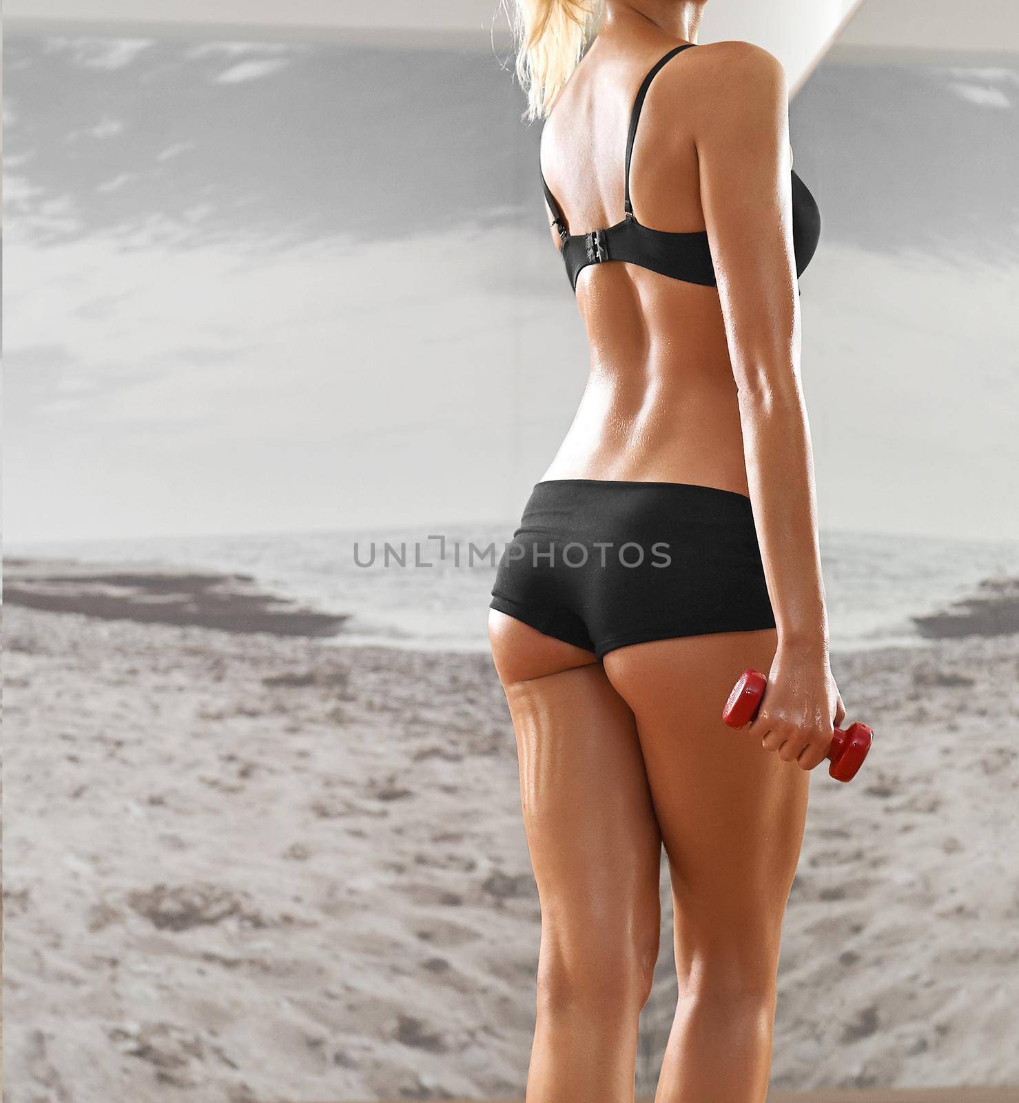 Sexy, athletic, blonde woman in the gym, against the background of the mirror, with dumbbells in hands. Sports, sportswear, health, a beautiful body, full-length portrait, body Parts