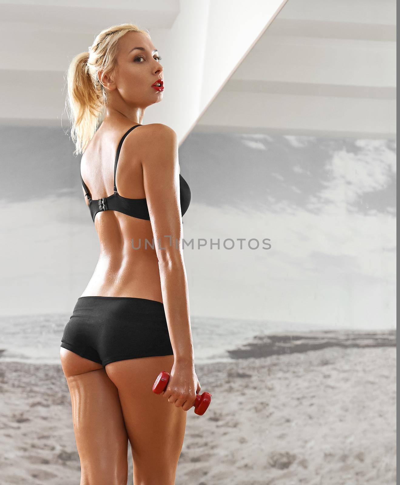 Sexy, athletic, blonde woman in the gym, against the background of the mirror, with dumbbells in hands. Sports, sportswear, health, a beautiful body, full-length portrait, body Parts