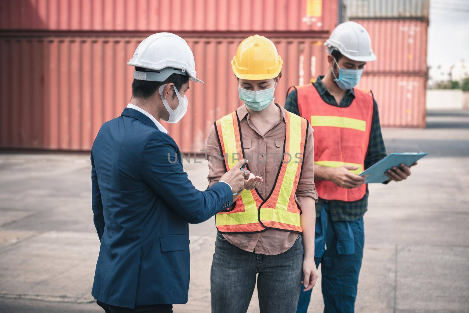 Coronavirus Covid-19 Disease Epidemic Crisis Situation, Container Shipping Worker Having Alcohol Gel Hands Cleaning Before Working at Warehouse Ship.Corona-Virus Covid19 Prevention/ New Normal Concept