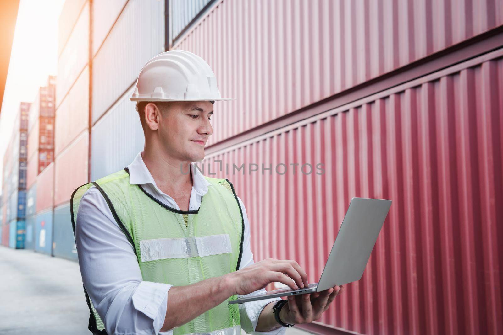 Container Shipping Logistics Engineering of Import/Export Transportation Industry, Transport Engineer is Controlling Management Containers Box on Laptop at Port Ship Loading Dock. Industrial Shipping