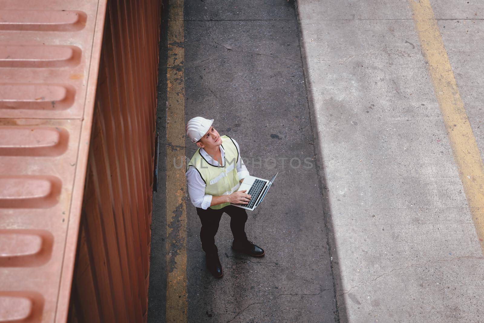 Container Shipping Logistics Engineering of Import/Export Transportation Industry, Transport Engineer is Controlling Management Containers Box on Laptop at Port Ship Loading Dock. Industrial Shipping by MahaHeang245789