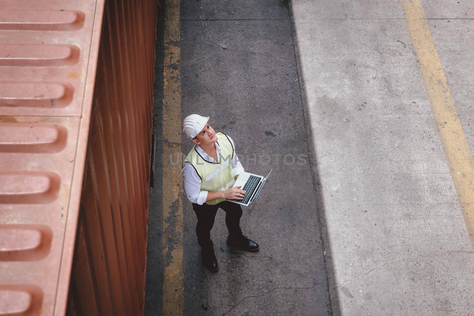 Container Shipping Logistics Engineering of Import/Export Transportation Industry, Transport Engineer is Controlling Management Containers Box on Laptop at Port Ship Loading Dock. Industrial Shipping