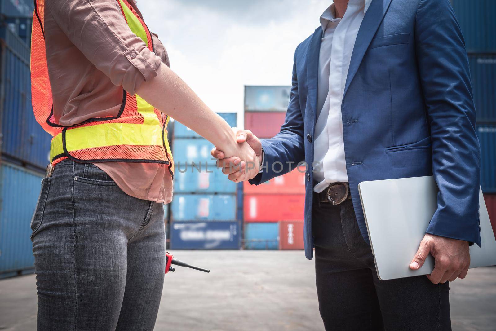 Businessman and Container Shipping Worker Handshake Together for Cooperation Shipment in Logistic Warehouse, Business Partnership Greeting Handshaking After Discussion Containers Transport Dealing. by MahaHeang245789