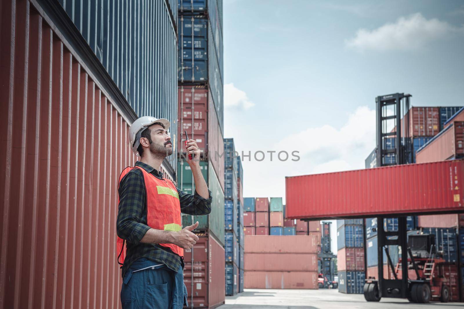 Container Logistics Shipping Management of Transportation Industry, Transport Engineer Managing Control Via Walkie Talkie in Containers Shipyard. Business Cargo Ship Import/Export Factory Logistic.