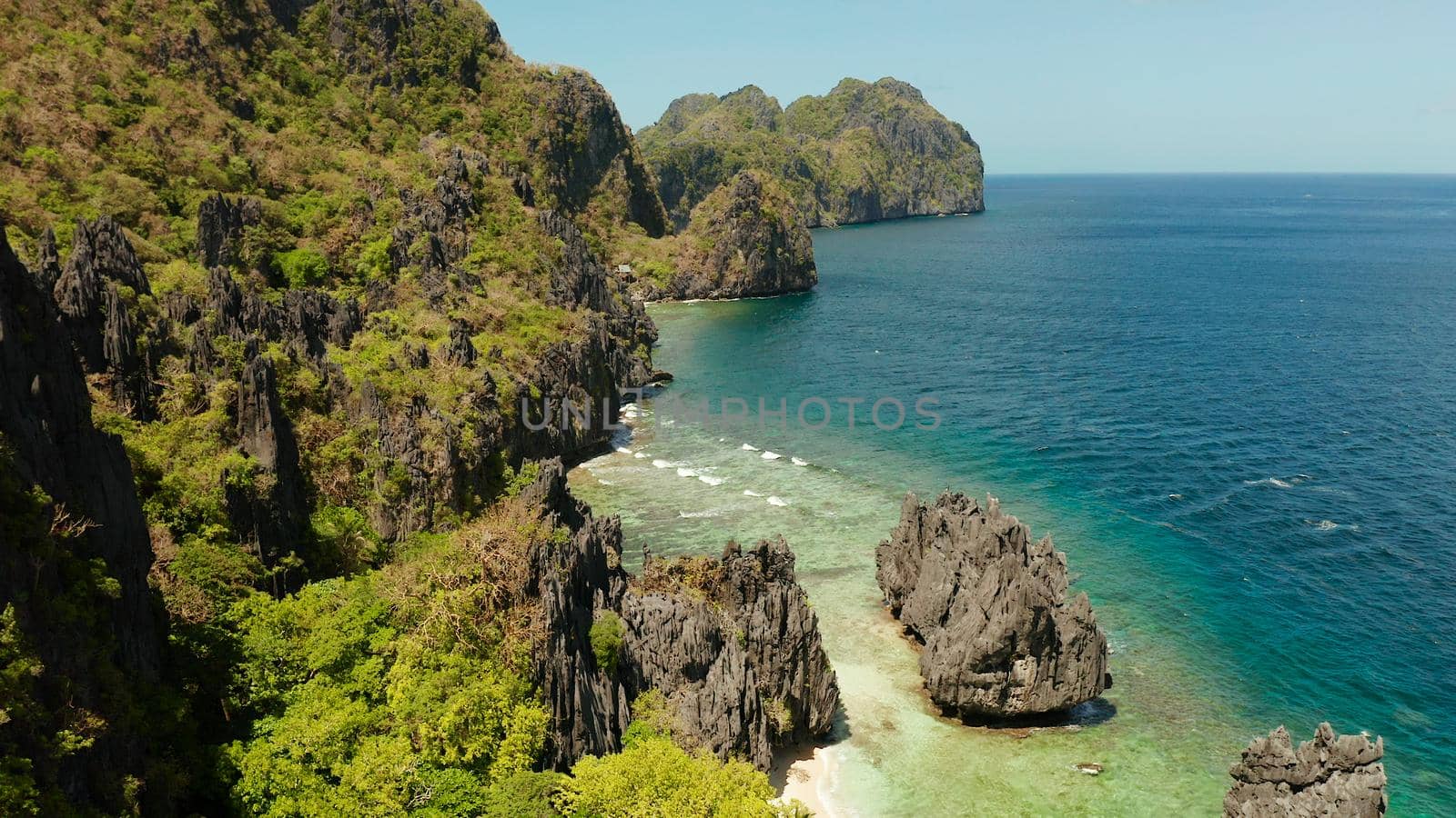 aerial view of tropical lagoon with sandy beach surrounded by cliffs. El nido, Philippines, Palawan. beautiful lagoon and karst scenery.