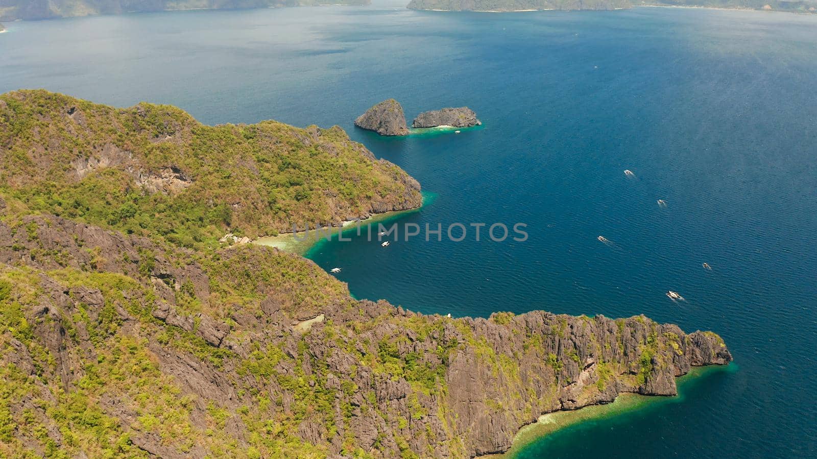 aerial view of bay and the tropical islands. Seascape with tropical rocky islands, ocean blue water. islands and mountains covered with tropical forest. El nido, Philippines, Palawan. Tropical Mountain Range