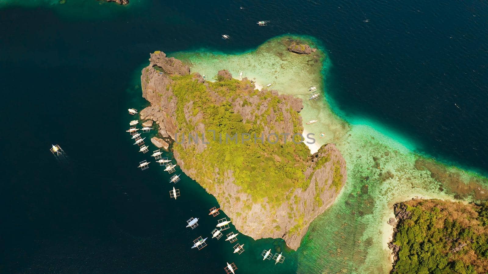 Tourist boats over tropical lagoon and coral reef. El nido, Philippines, Palawan. tropical landscape bay with beach and clear blue water surrounded by cliffs