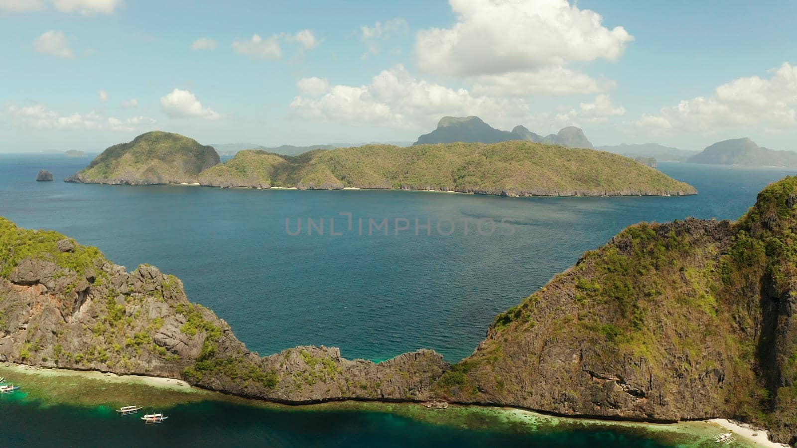 Seascape with tropical rocky islands, ocean blue water, aerial view . islands and mountains covered with tropical forest. El nido, Philippines, Palawan. Tropical Mountain Range