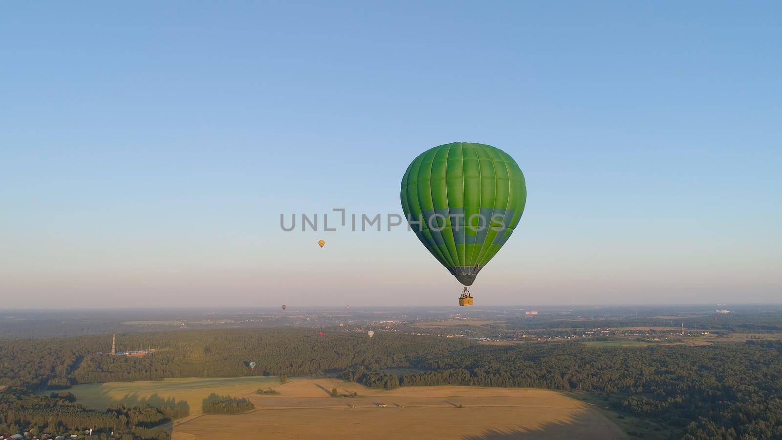 Aerial view Hot air balloon in sky over fields in countryside, beautiful sky and sunset. Aerostat fly over countryside.
