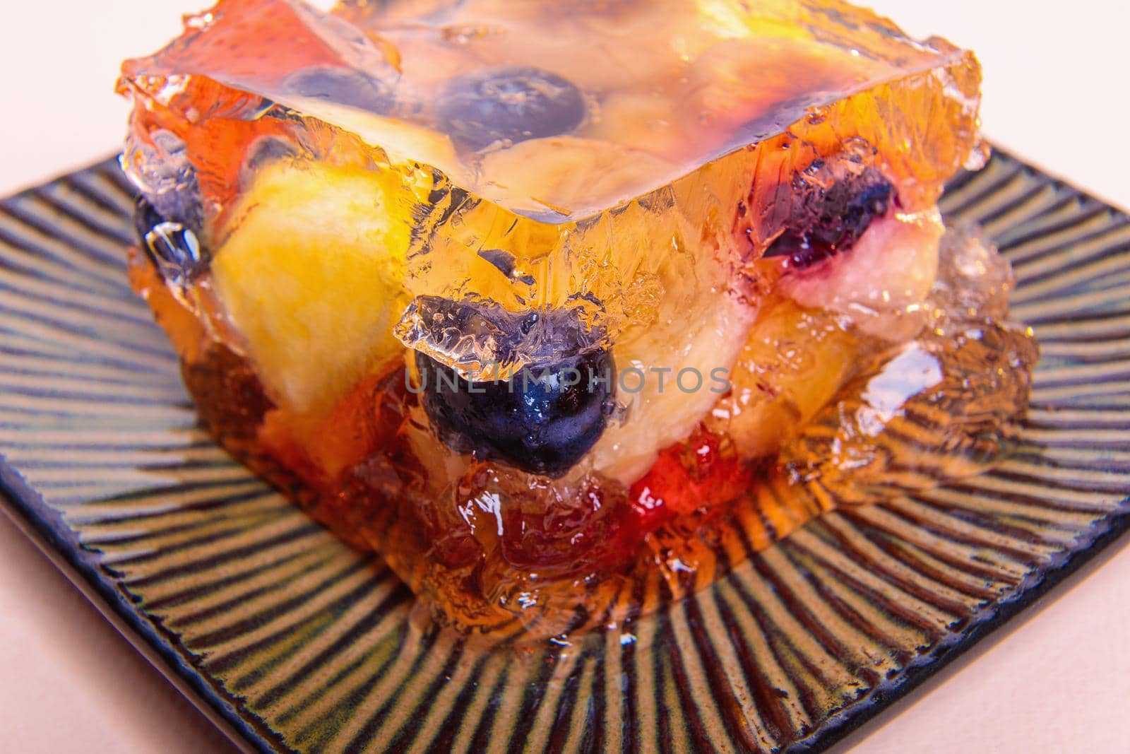 Jelly from different fruits and berries on a square saucer. Dessert. Close-up
