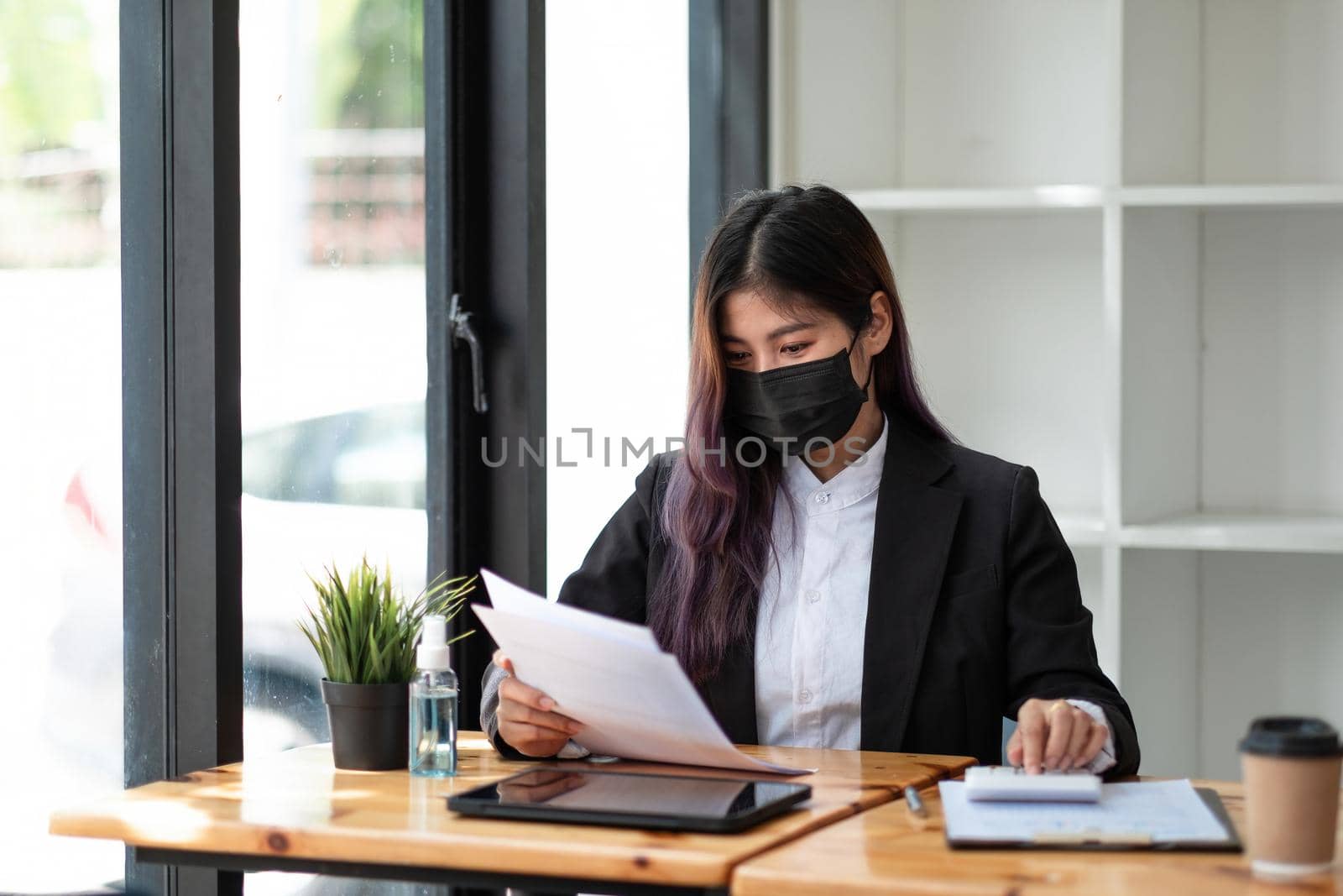 Business woman wear mask while using calculator with computer laptop, Business accounting, budget and loan paper in office.