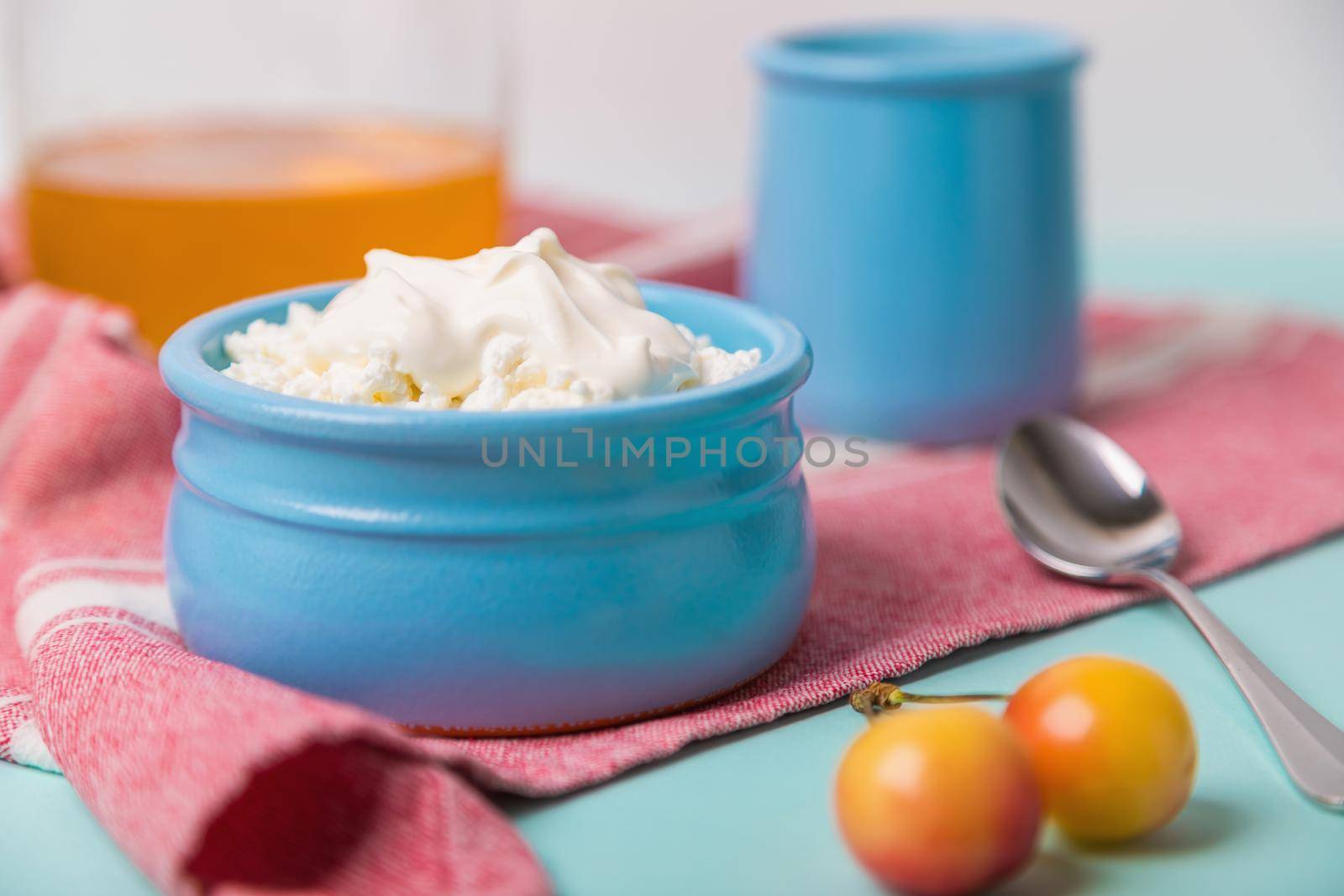 Cottage cheese in a blue bowl with sour cream and honey. Morning breakfast.