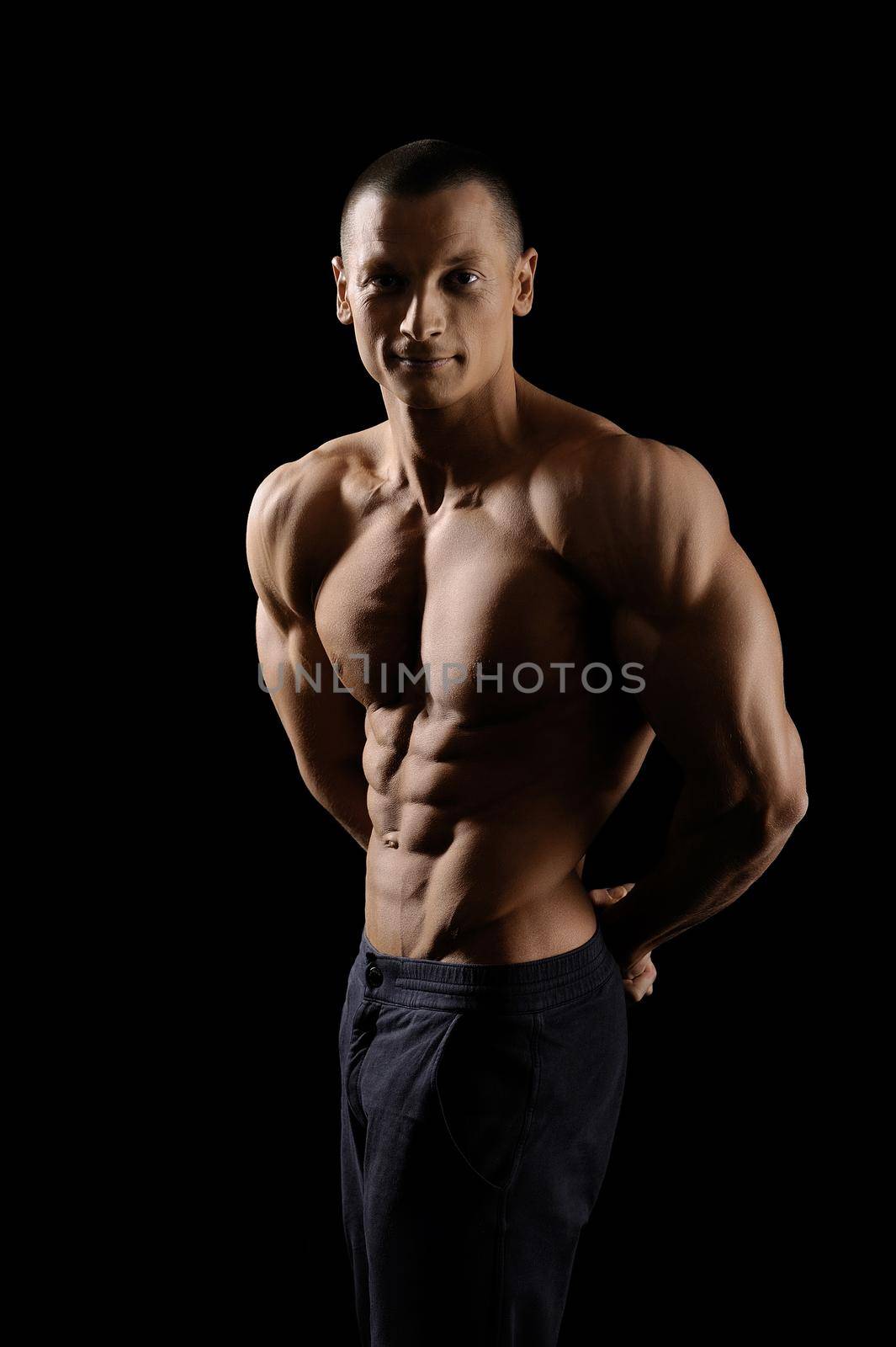 Muscular fitness man on black background by SerhiiBobyk