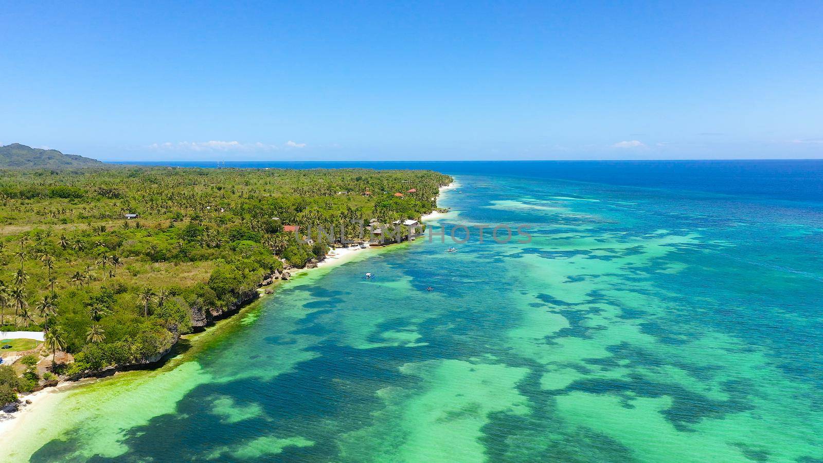 Coast with a sandy beach and azure water surrounded by a coral reef. Bohol, Anda, Philippines. Summer and travel vacation concept.