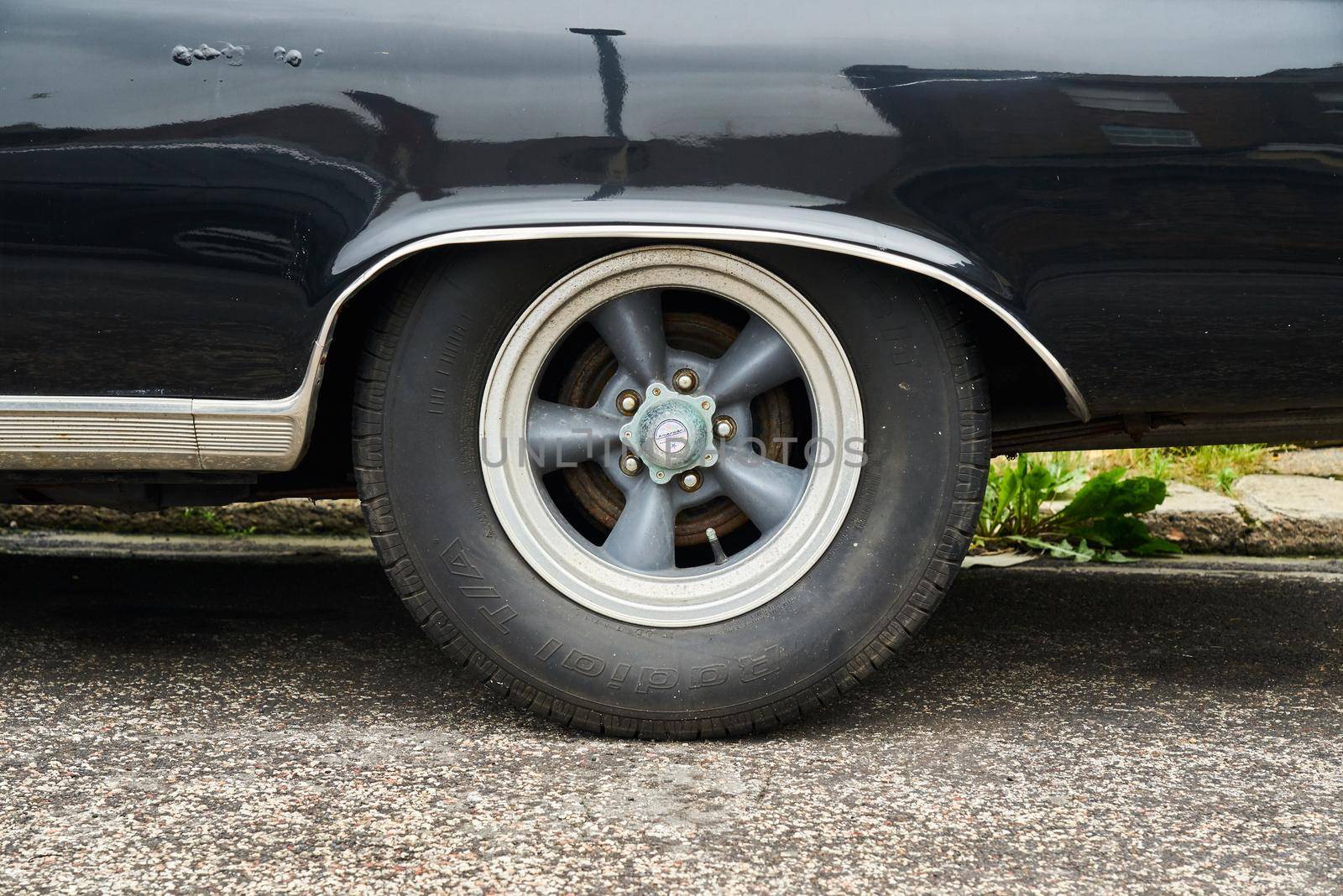 The wheel and wheel arch of a black 2 door convertible 1965 Dodge Coronet 500