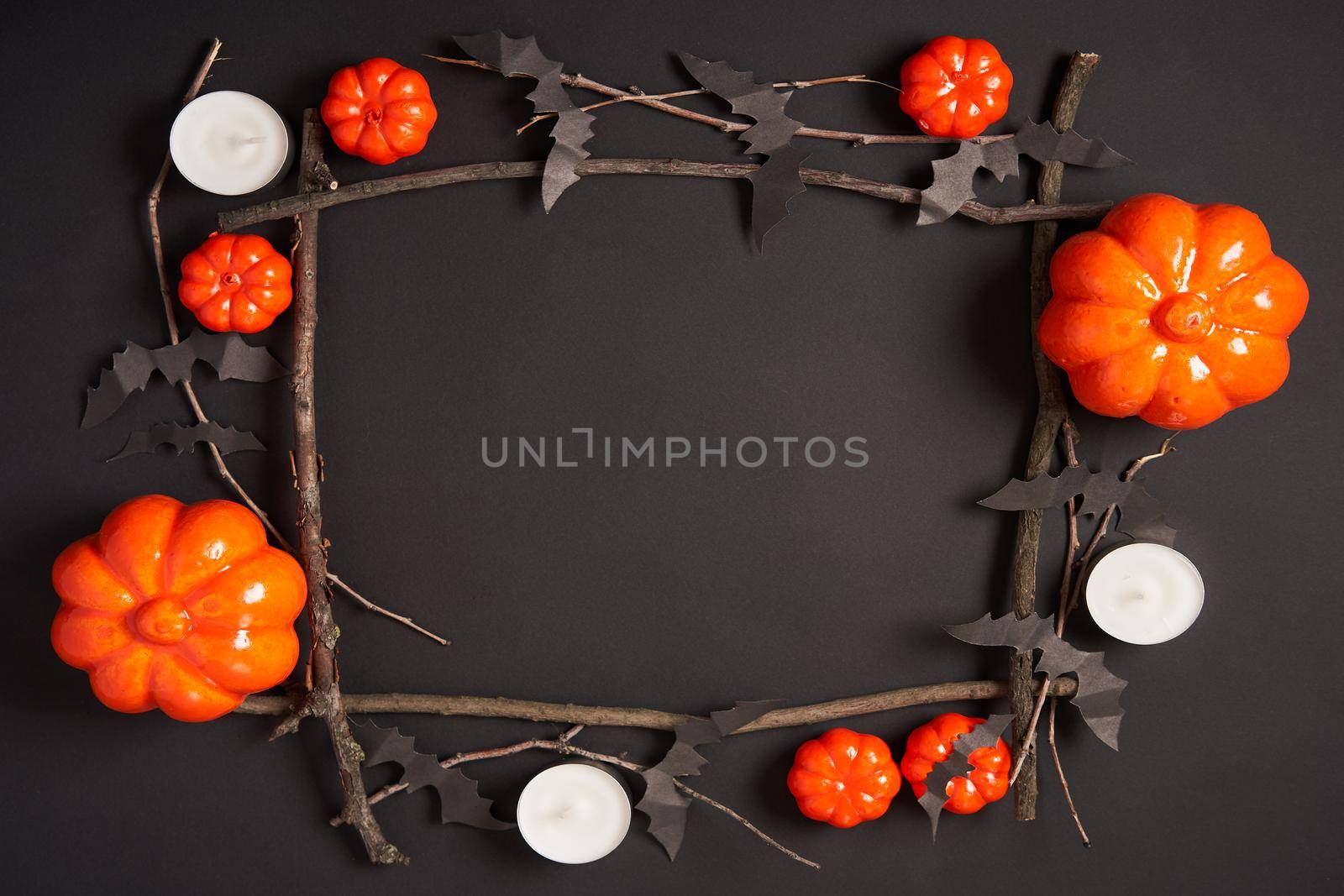 Halloween background, orange decorative plastic pumpkin black paper bat dry branch stick square frame black cardboard Thanksgiving greeting card pattern