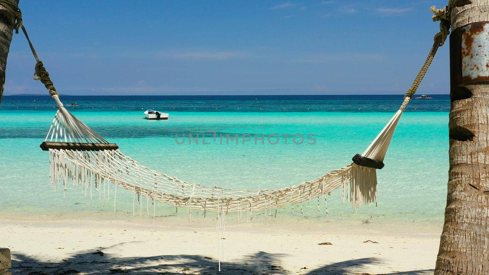 Tropical beach with with hammock and palm trees. Beautiful beach and tropical sea. Panglao island, Bohol, Philippines. Summer and travel vacation concept.