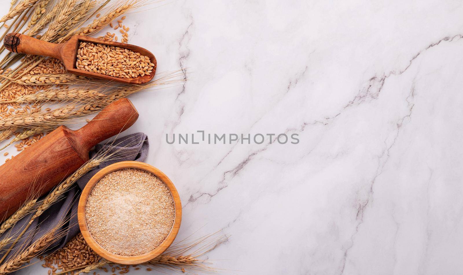 Wheat ears and wheat grains set up on marble background. Top view and copy space by kerdkanno
