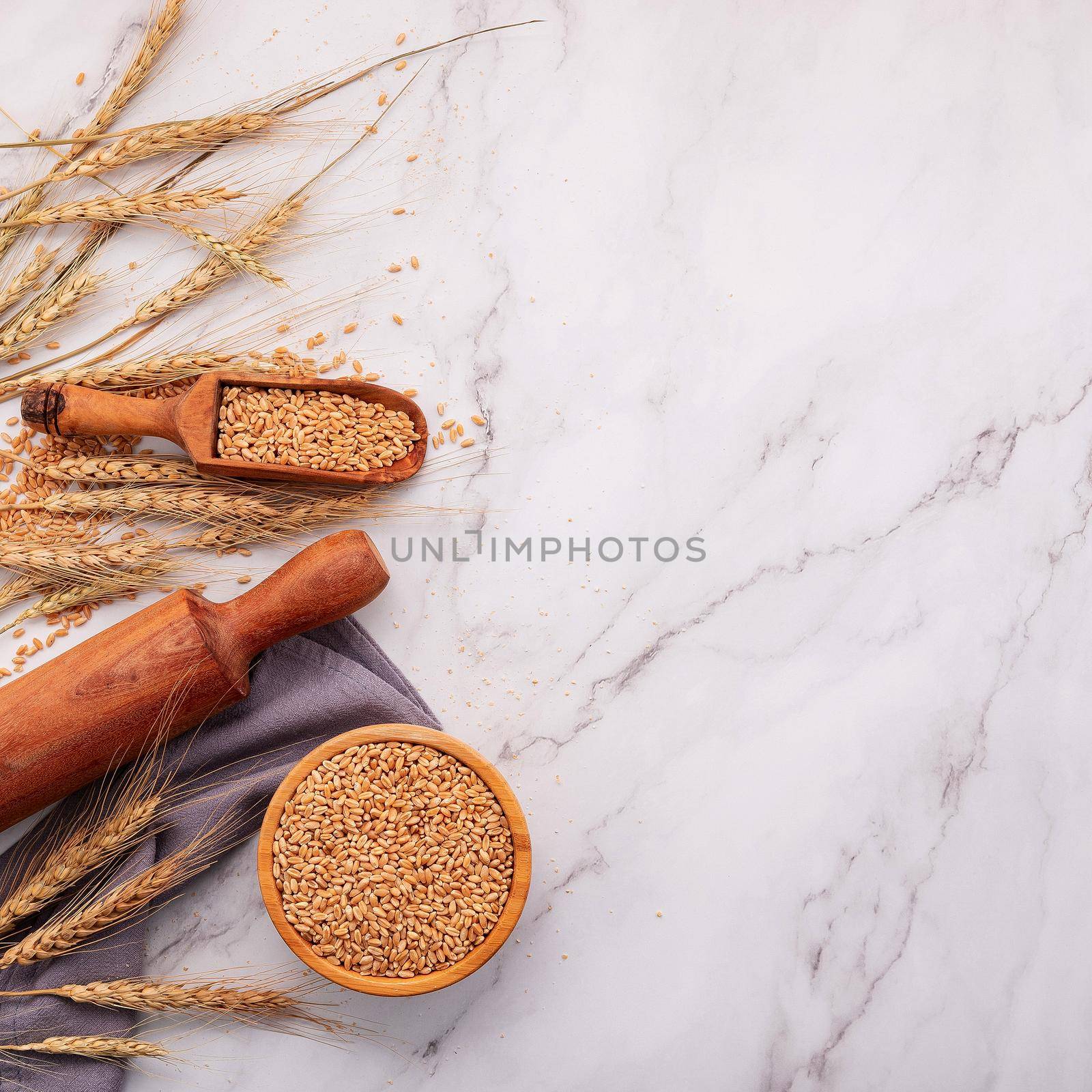 Wheat ears and wheat grains set up on marble background. Top view and copy space