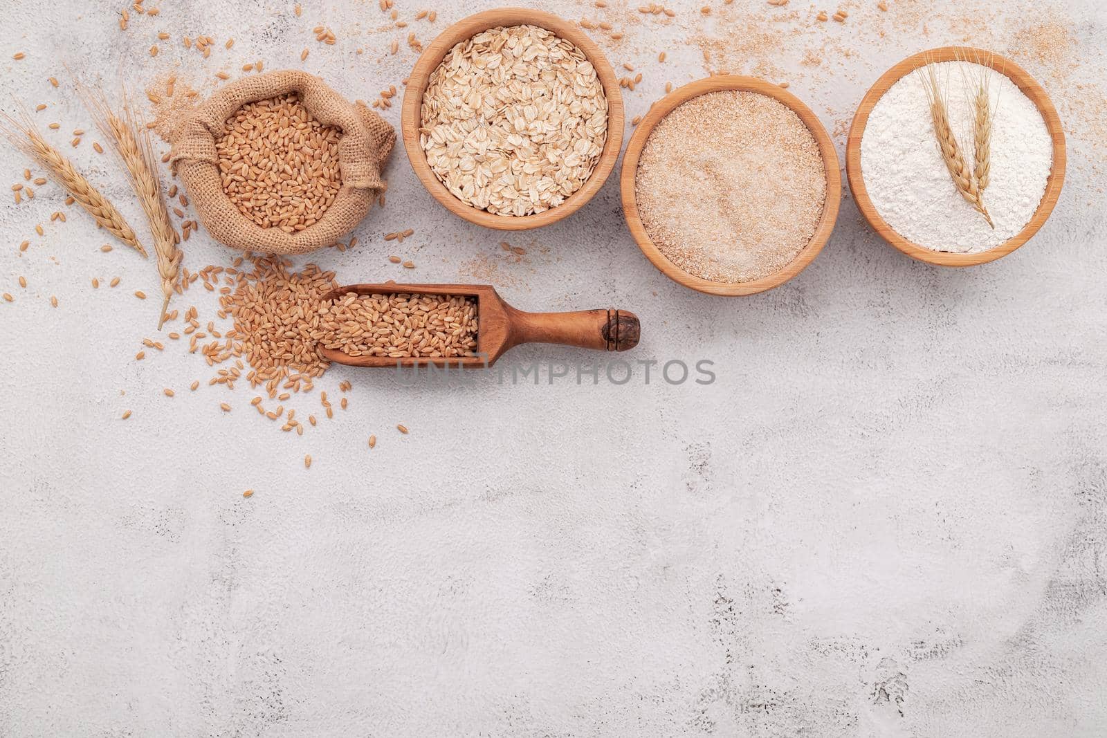  Wheat grains , brown wheat flour and white wheat flour in wooden bowl set up on white concrete background. by kerdkanno