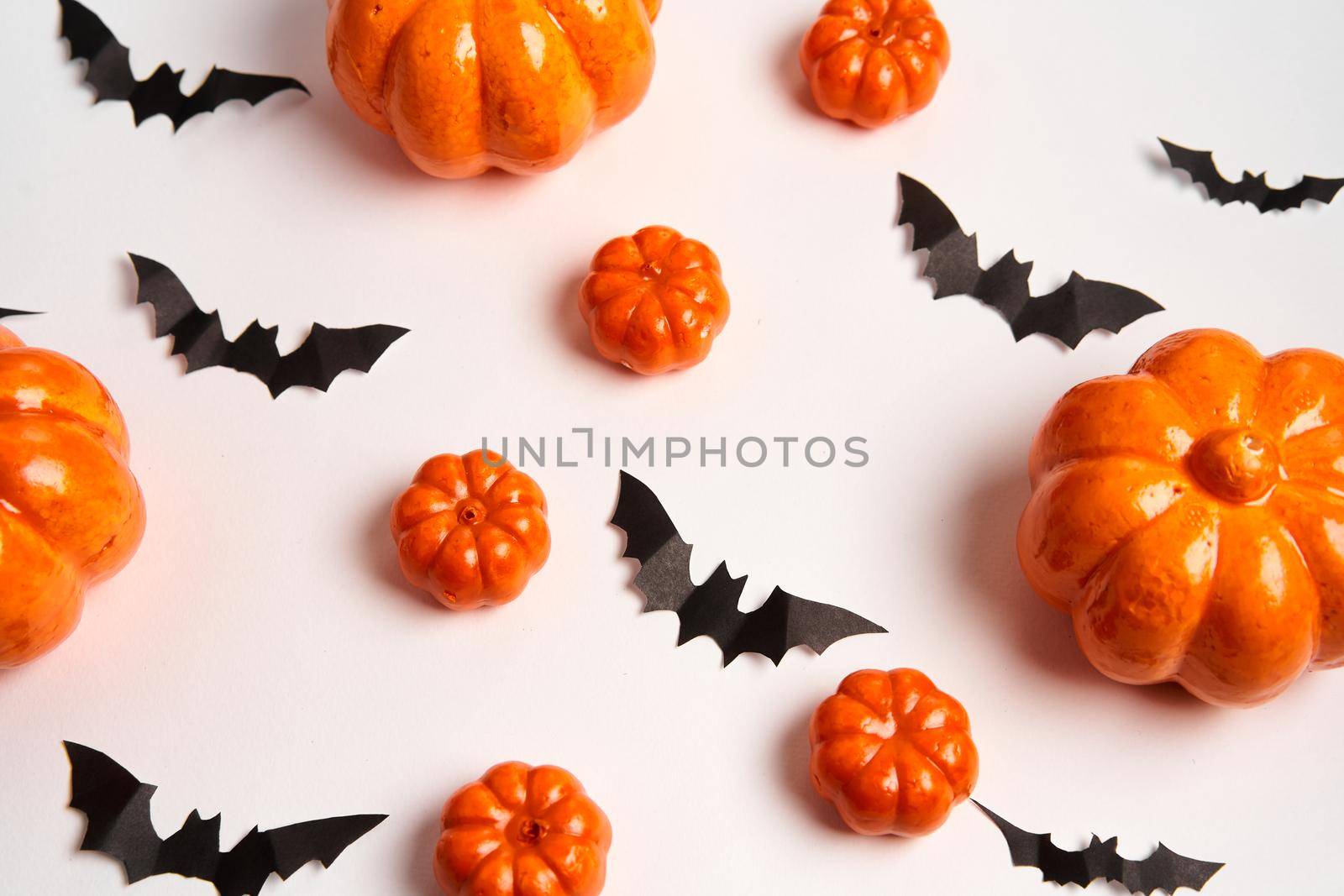 Halloween background, orange decorative plastic pumpkin black paper bat white cardboard Thanksgiving greeting card pattern