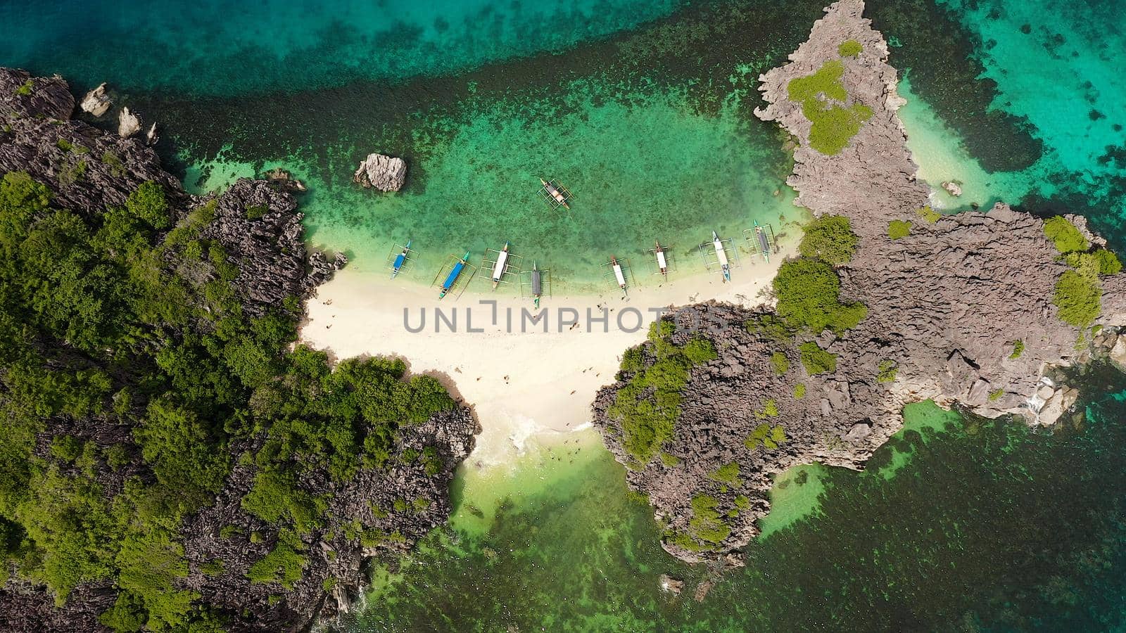 Tropical island with sandy with tourists and blue sea, aerial view. Lahos Island, Caramoan Islands, Philippines. Summer and travel vacation concept.