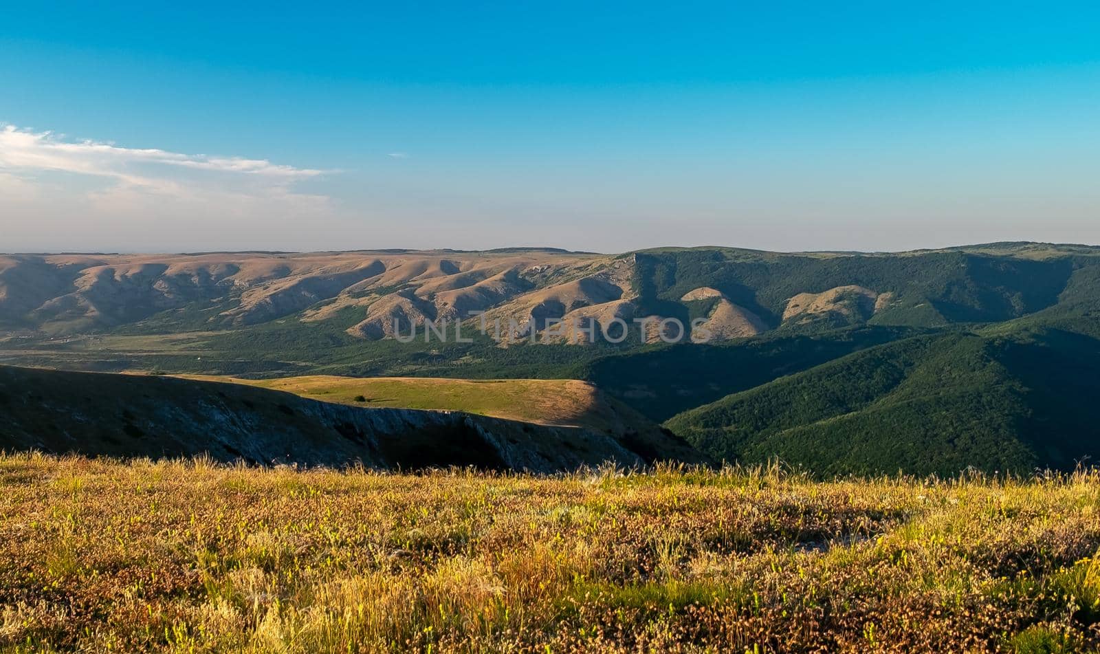 Pid to the surrounding mountains from the lower plateau of Chatyr-Dag in Crimea in the light of the setting sun.