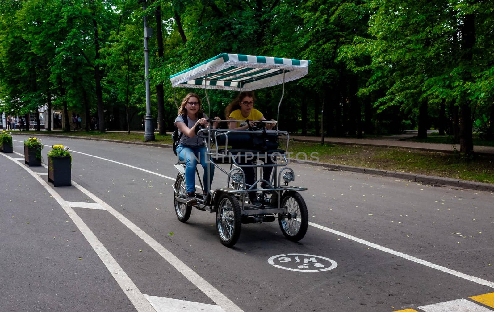 May 30, 2019, Moscow, Russia. Two girls ride a cycle rickshaw in Soklniki Park in Moscow.