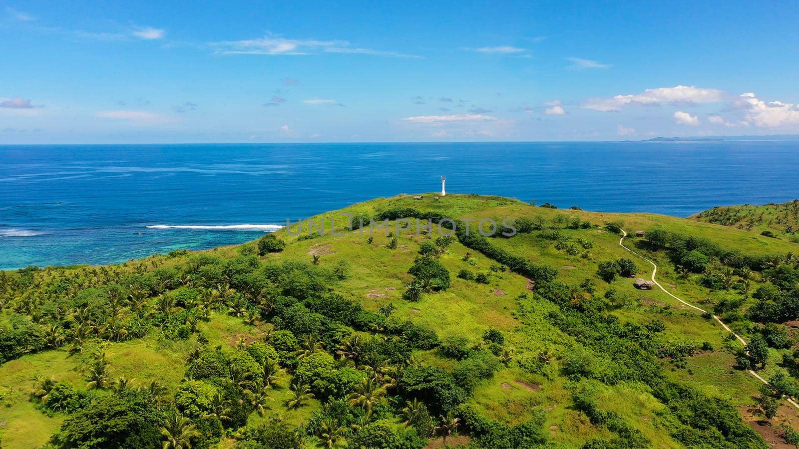Lighthouse on a tropical island, top view. Beautiful landscape with a green island. Summer and travel vacation concept. Basot Island, Caramoan, Camarines Sur, Philippines.