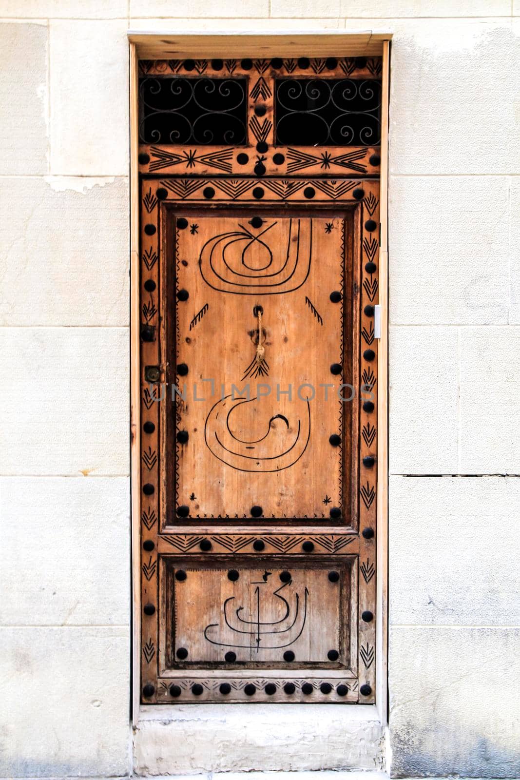 Old and colorful wooden door with iron details in Alicante, Spain