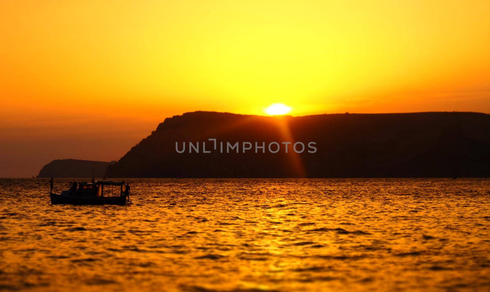 A pleasure boat in a quiet bay of the Black Sea in the light of the setting sun.